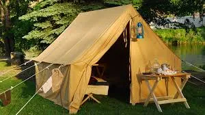 A canvas tent is set up in a wooded area. One flap is open. A table containing cooking items is outside.