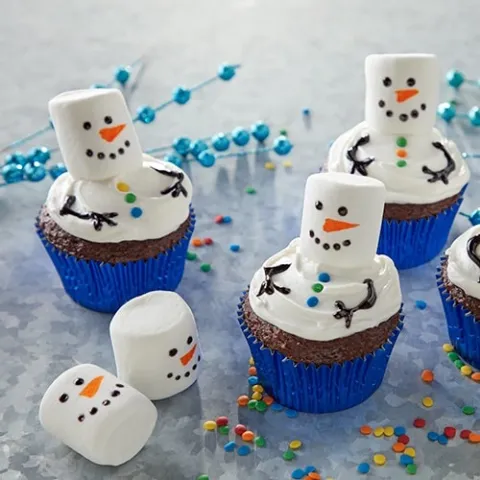cupcakes with marshmallow and frosting decorations that look like a melted snowman