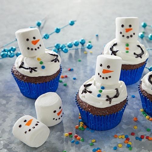 cupcakes with marshmallow and frosting decorations that look like a melted snowman